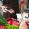 Shopper using a grocery store loyalty card at checkout