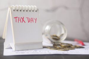 Coins in a savings jar beside a calendar, illustrating how to automate savings on payday in 2026