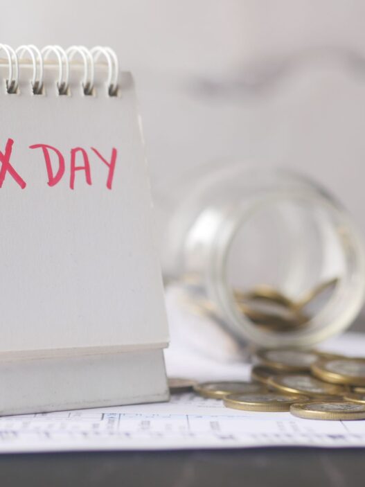 Coins in a savings jar beside a calendar, illustrating how to automate savings on payday in 2026