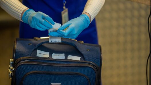 A traveler with luggage at an airport check-in counter, illustrating how to avoid airline baggage fees in 2026