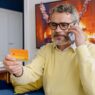 Person on a phone call holding a credit card at a desk