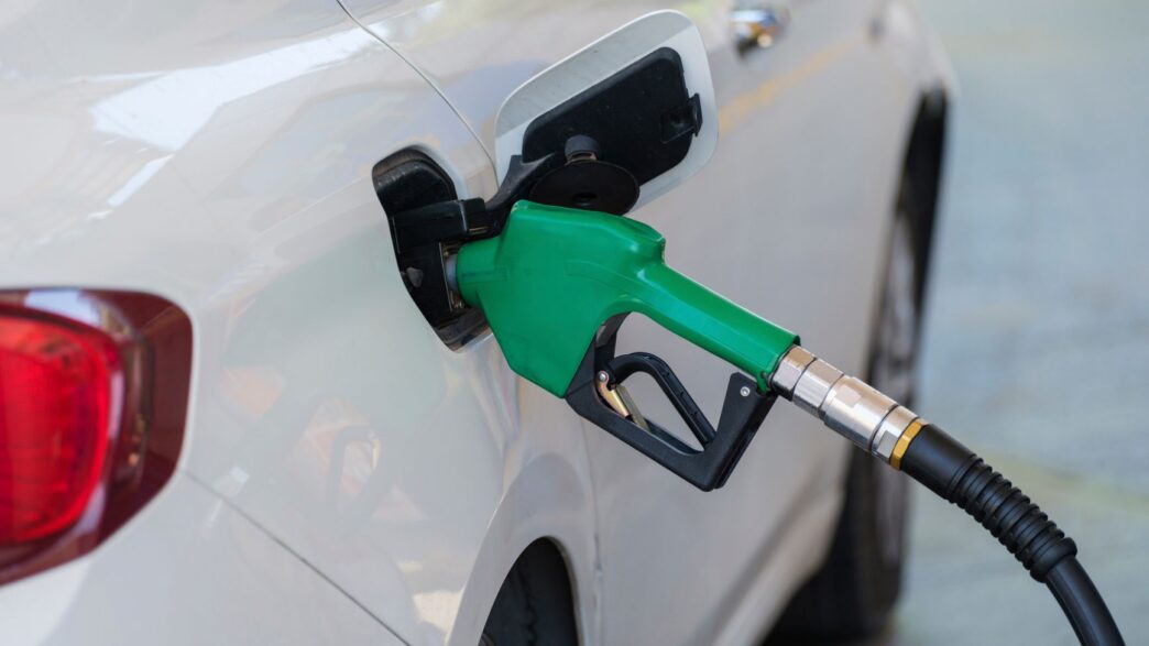 A car being refueled at a gas station pump, representing grocery fuel rewards savings