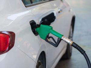 A car being refueled at a gas station pump, representing grocery fuel rewards savings