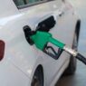 A car being refueled at a gas station pump, representing grocery fuel rewards savings