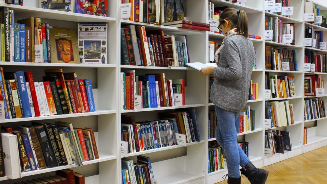 College student studying with textbooks in a library