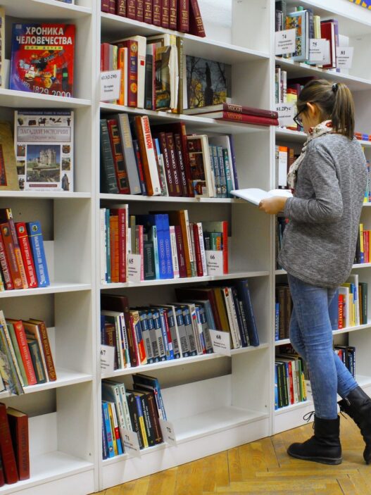 College student studying with textbooks in a library