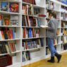 College student studying with textbooks in a library