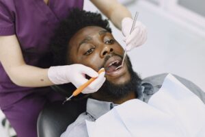 A dental patient at a checkup, illustrating ways to save on dental care without insurance in 2026