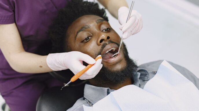 A dental patient at a checkup, illustrating ways to save on dental care without insurance in 2026