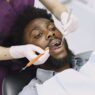 A dental patient at a checkup, illustrating ways to save on dental care without insurance in 2026