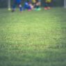 Children playing youth soccer on a grass field