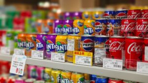 A shopper comparing prices on a grocery store shelf, illustrating how to use unit pricing to save money