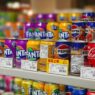 A shopper comparing prices on a grocery store shelf, illustrating how to use unit pricing to save money