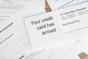Credit cards and bills on a desk next to a calculator and budget notes