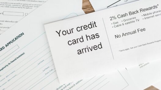 Credit cards and bills on a desk next to a calculator and budget notes