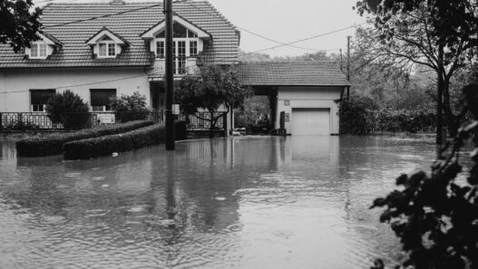 Floodwater covering a residential street outside homes