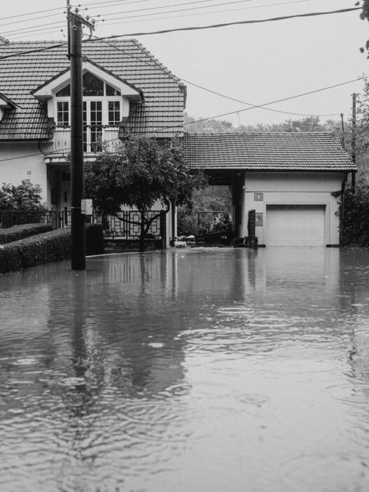 Floodwater covering a residential street outside homes