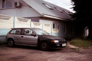 A single car parked in a suburban driveway after a household downsized to one vehicle