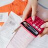Medical bills and a calculator on a desk, used to review hospital bill financial assistance options