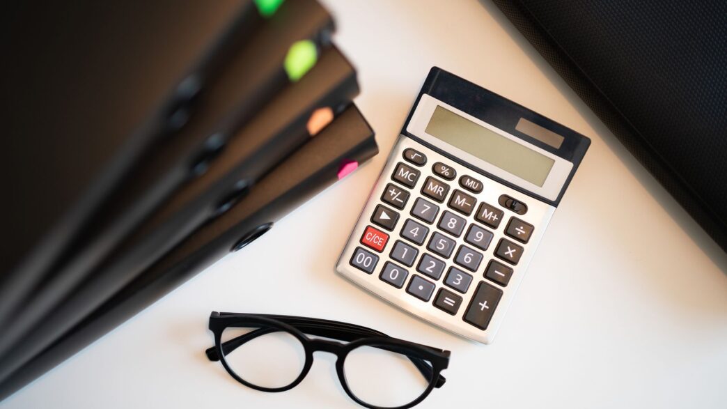 Student loan statement and calculator on a desk while planning a lower monthly payment
