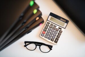 Student loan statement and calculator on a desk while planning a lower monthly payment