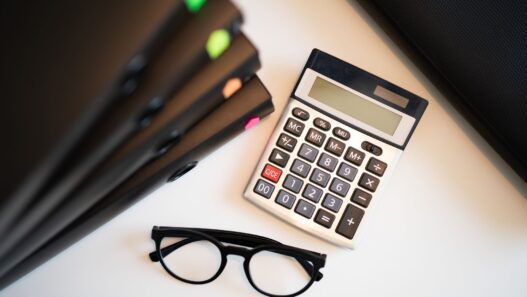 Student loan statement and calculator on a desk while planning a lower monthly payment