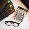 Student loan statement and calculator on a desk while planning a lower monthly payment