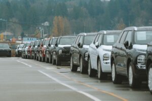 Rows of new vehicles on a car dealership lot during model-year clearance season