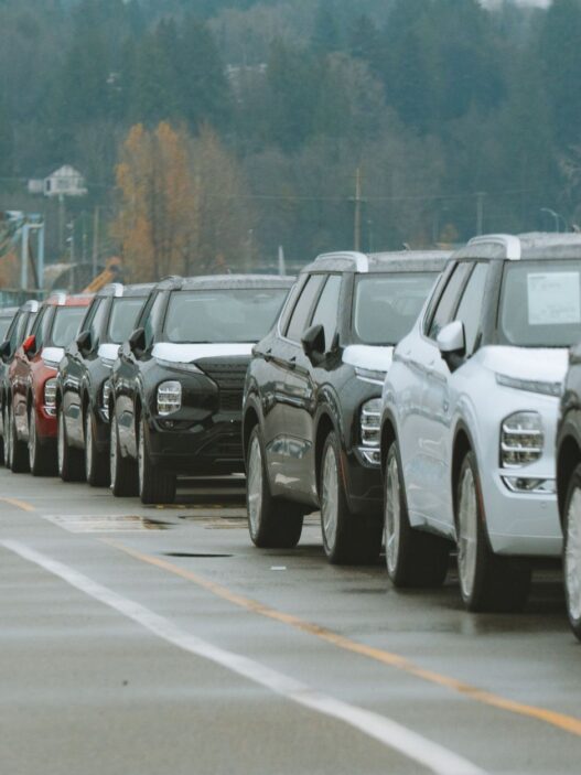 Rows of new vehicles on a car dealership lot during model-year clearance season