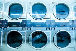New white front-load washing machines lined up in an appliance showroom