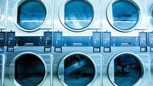 New white front-load washing machines lined up in an appliance showroom