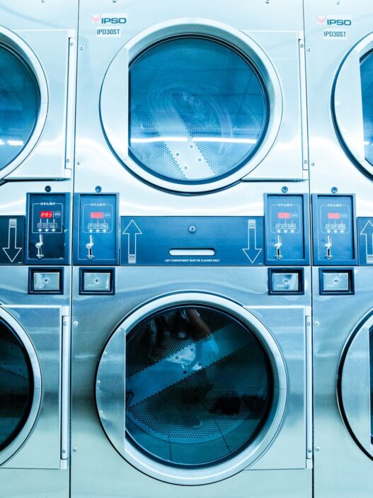 New white front-load washing machines lined up in an appliance showroom