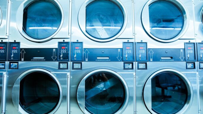 New white front-load washing machines lined up in an appliance showroom