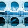 New white front-load washing machines lined up in an appliance showroom