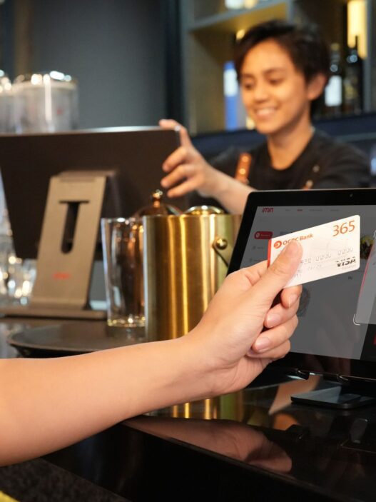 A customer paying at a restaurant counter with a card payment terminal