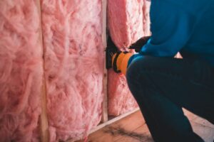 Attic insulation being installed to improve home energy efficiency
