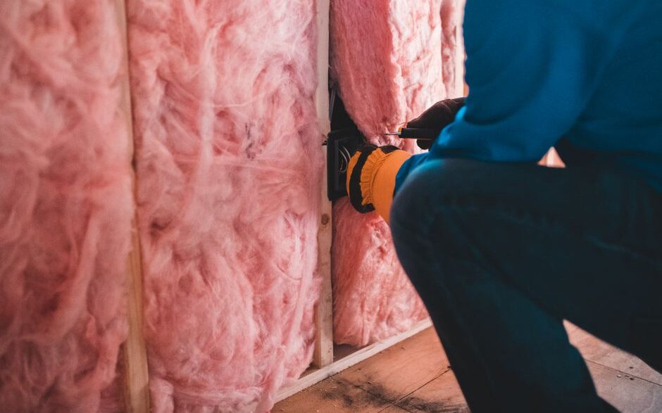 Attic insulation being installed to improve home energy efficiency