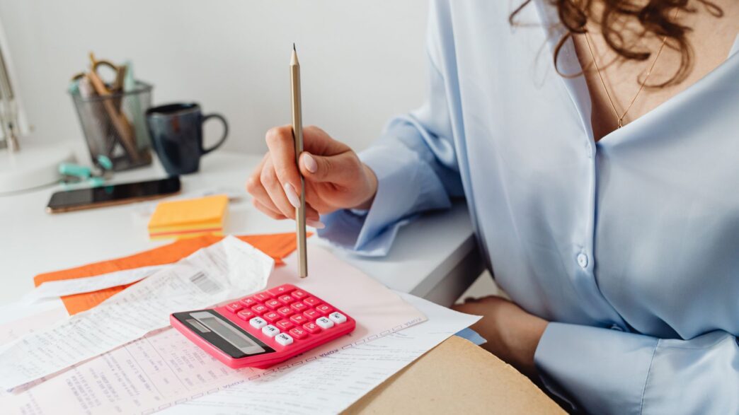 Household bills and a calculator on a desk during budget planning