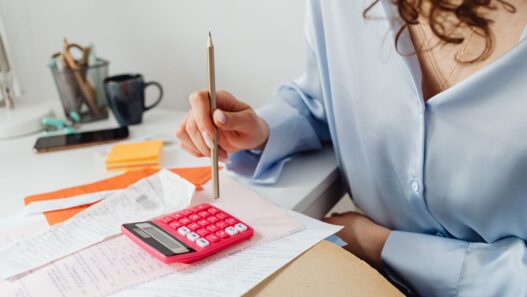 Household bills and a calculator on a desk during budget planning