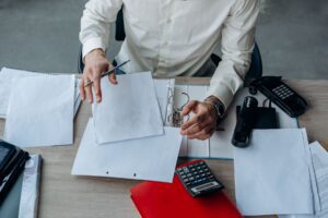 Worker reviewing employee benefits enrollment paperwork at a desk