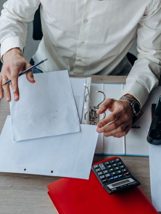 Worker reviewing employee benefits enrollment paperwork at a desk