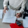 Worker reviewing employee benefits enrollment paperwork at a desk