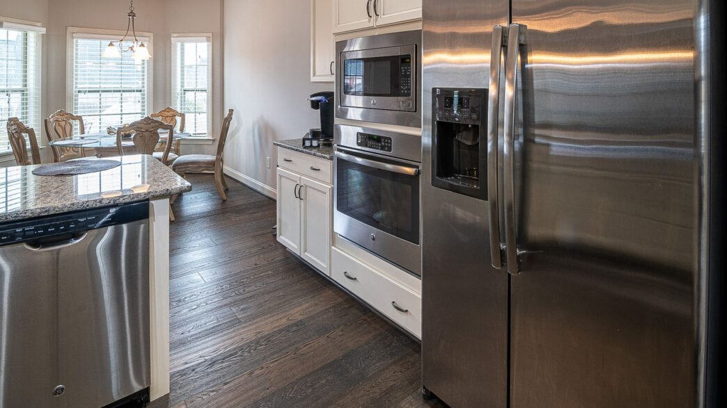 Row of new refrigerators and washing machines on display in an appliance showroom