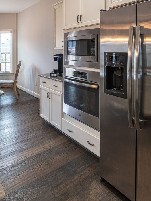 Row of new refrigerators and washing machines on display in an appliance showroom