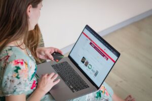 Person holding a credit card while shopping online on a laptop