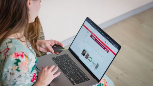 Person holding a credit card while shopping online on a laptop