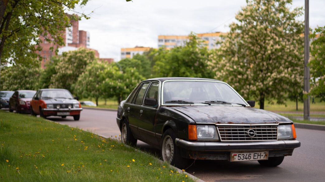 An older sedan parked along a residential street