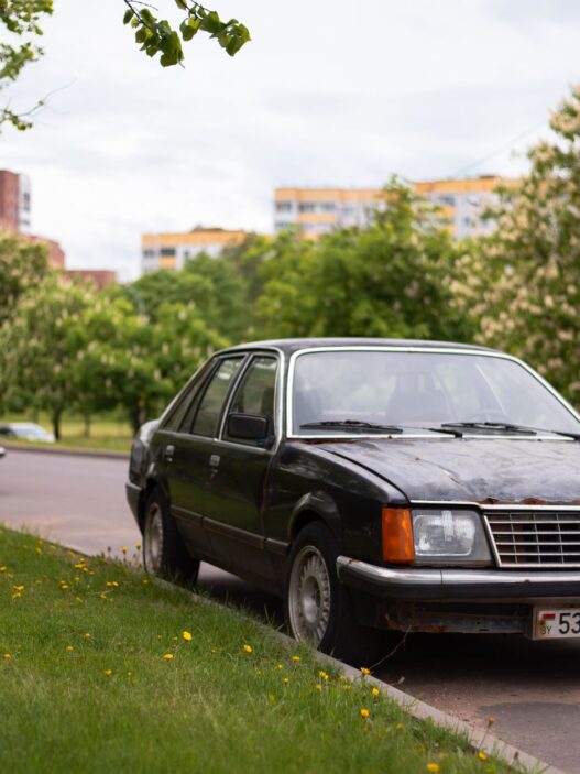 An older sedan parked along a residential street
