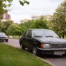 An older sedan parked along a residential street