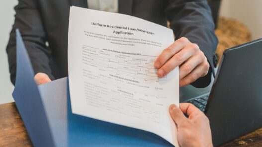 Student and parent filling out a financial aid application on a laptop at a kitchen table